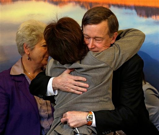 Colorado Gov. John Hickenlooper, right, is hugged by Rep. Rhonda Fields, D-Aurora, Wednesday after he signed gun control bills into law at the Capitol in Denver . Fields was a co-sponsor of bills on background checks and the size of ammunition magazines.