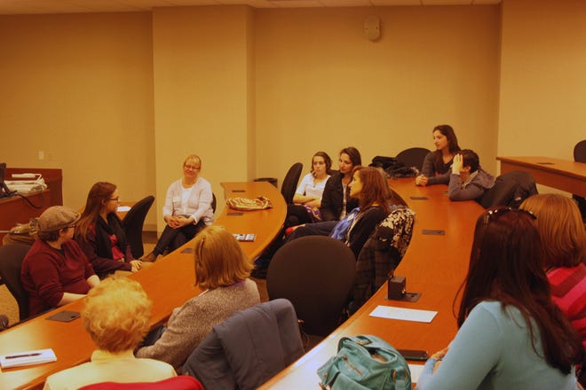 Members of the Monmouth branch of the Association of American University Women talk with Monmouth College students Tuesday evening after a screening of the film, “Miss Representation.”