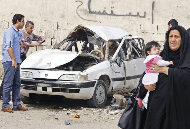 Hadi Mizban/Associated Press People inspect a damaged car Wednesday at the scene of a car bomb attack in the Zayona neighborhood of eastern Baghdad, Iraq.