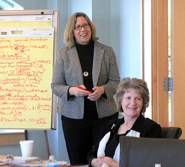 Mary Tschirhart, standing, a North Carolina State University professor and entrepreneur of the year, addresses the Swiss Bear Board of Directors Thursday morning. Seated is Danielle Glynn, Swiss Bear’s administrative assistant.