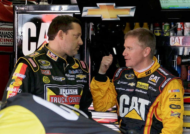 Defending champion Tony Stewart, left, and Jeff Burton chat before practice for the NASCAR Sprint Cup series Auto Club 400 auto race in Fontana, Calif., Friday, March 22, 2013. (AP Photo/Reed Saxon)