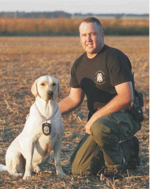 The Kansas Department of Wildlife, Parks and Tourism's K9 program began in 2003 and was initiated by natural resource officer Jason Barker. Barker, pictured here with his late dog, Moose, helped solicit $20,000 in donations from businesses and individuals for initial start-up and training costs.