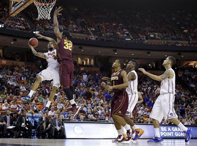 Florida's Mike Rosario, left, is fouled by Minnesota's Trevor Mbakwe (32) as he tries to score during the first half of a third-round game of the NCAA college basketball tournament, Sunday, March 24, 2013, in Austin, Texas.