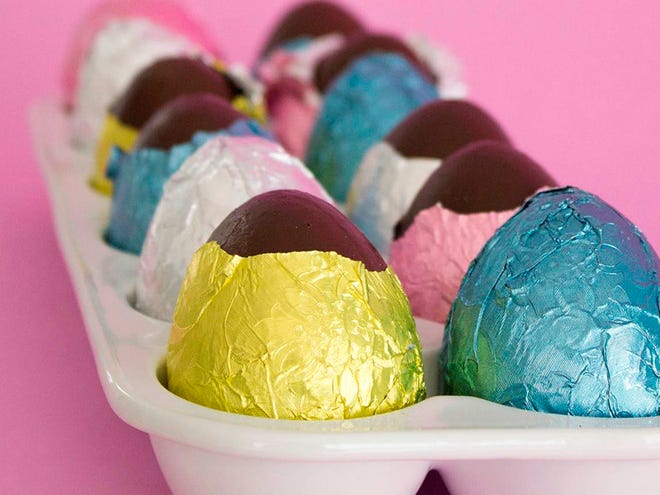 Faux chocolate eggs are made by painting papier-mâché forms and wrapping them in colored foil.