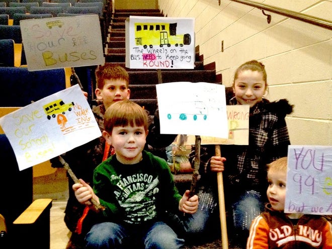 Pemberton Township students (clockwise from top left) Anthony Smith, Melody Beam, Ben Young and Mavrick Willits show posters they made in favor of keeping courtesy busing to the township's schools.
