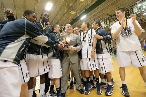 File Photo by Amy Herzog/New Jersey Herald Pope John players gather around coach Jason Hasson to celebrate their second straight championship in the HWS Tournament. Despite their ups and downs, the Lions emerged as the Herald’s 2012-2013 Team of the Year.