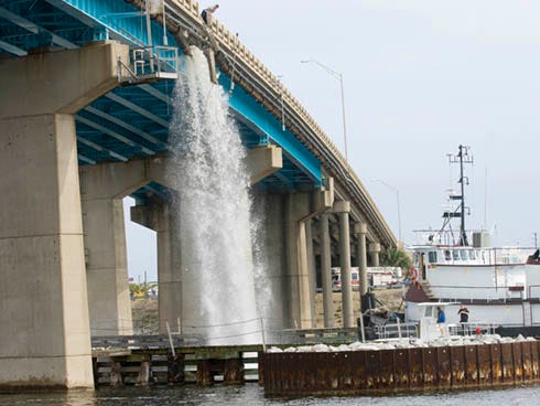 A crane on a barge struck Brooks Bridge on Wednesday afternoon, destroying part of a guardrail and rupturing a pipe carrying water to Okaloosa Island.
