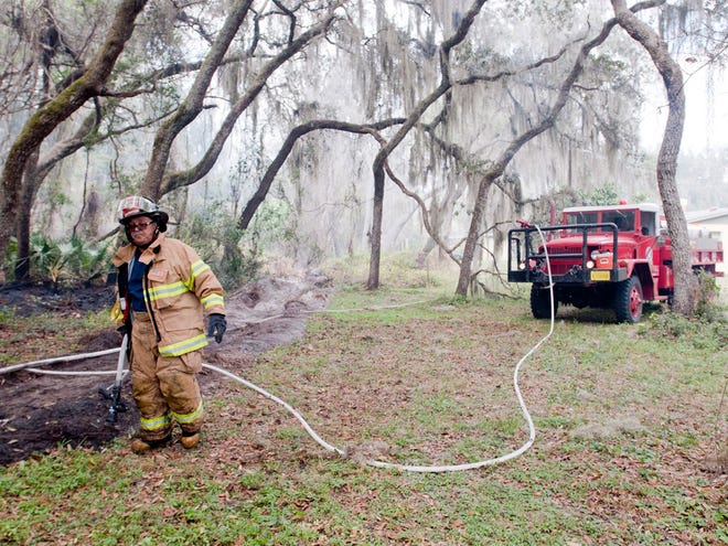 In this March 3, 2013 file photo, a firefighter with Marion County Fire Rescue works on a plow line to contain a wildfire in the Ocala National Forest just south of Salt Springs. Resident are urged to avoid outdoor burning because of dry conditions.