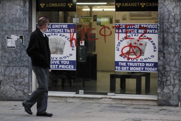 A man passes a sprayed entrance of a store that buys gold which reads in Greek " thieves" in capital Nicosia, Cyprus, Monday, March 25, 2013. Cyprus secured what its politicians described as a ìpainfulî solution to avert imminent bankruptcy, agreeing early Monday to slash its oversize banking sector and make large account holders take losses to help pay to secure a last-minute euro10 billion (US$13 billion) bailout. (AP Photo/Petros Giannakouris) ORG XMIT: XPG115