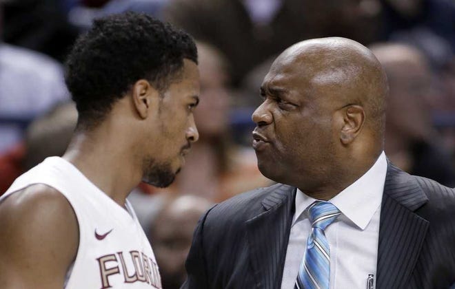 Florida State coach Leonard Hamilton, right, stares at Devon Bookert, left, as he walks off the court during the first half of an NCAA college basketball game against Clemson at the Atlantic Coast Conference men's tournament in Greensboro, N.C., Thursday, March 14, 2013. (AP Photo/Bob Leverone)