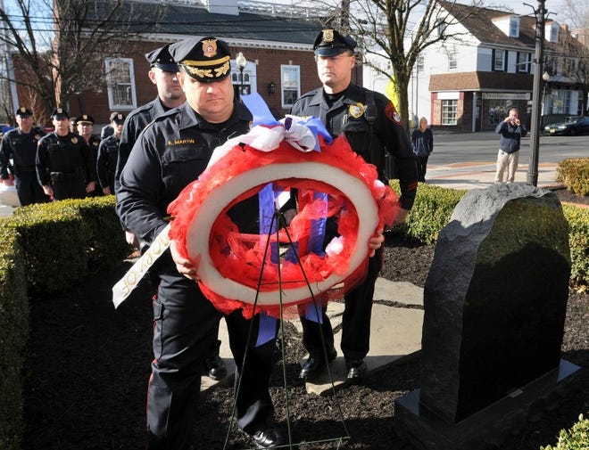 Mount Holly Chief of Police Steven Martin places a wreath at the memorial for fallen Mount Holly police officers Donald Alshire and John Holmes and Hainesport police officer William Wurst during a ceremony on Thursday morning. Two officers died on March 28, 1975 the other officer died at a later date from the wounds suffered during a sniper attack in the Mount Holly.