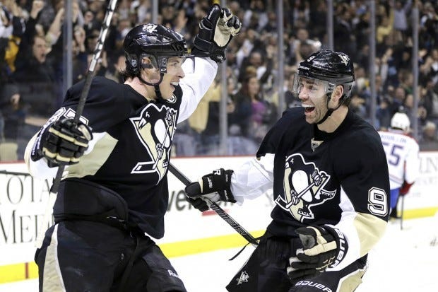 Pittsburgh Penguins center Sidney Crosby, left, celebrates his goal with right wing Pascal Dupuis (9) in the second period of an NHL hockey game against the Montreal Canadiens in Pittsburgh Tuesday, March 26, 2013.(AP Photo/Gene J. Puskar)