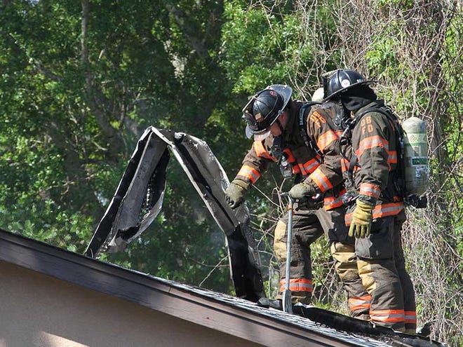 Firefighters work a fire at a home on Center Street in Holly Hill Friday morning, March 29, 2013.