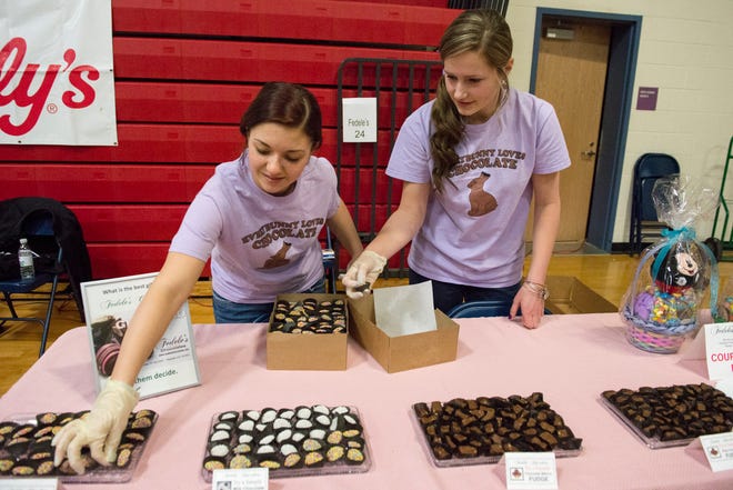 Elizabeth MacDonald, left, and Holly MacCormick of Fedele's Chocolate lay out tasty treats during the Taste of Pembroke held Sunday, March 24, 2013, at Pembroke High School.