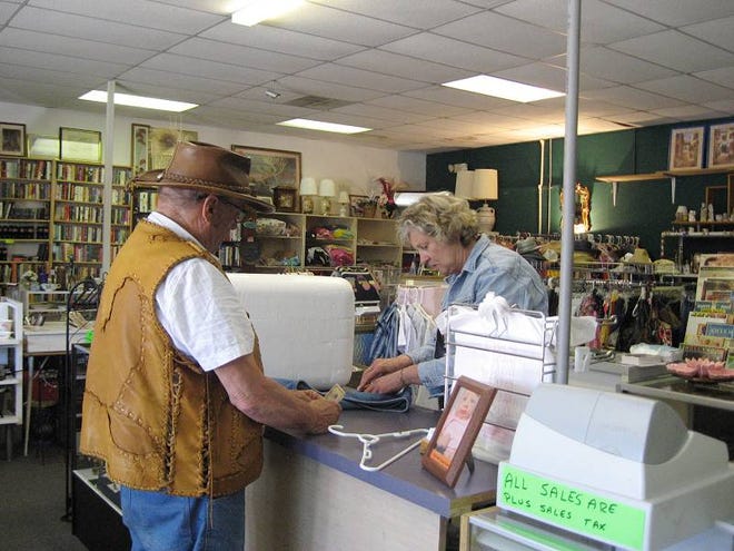 Sonia Rusby, right, rings up shopper Ken Paro’s purchase this week at Charson’s Treasures in Flagler Beach.