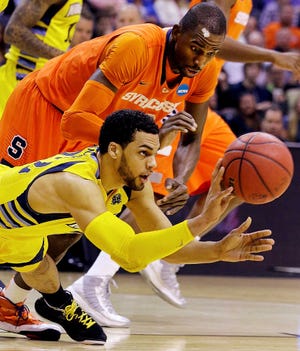 Marquette guard Trent Lockett (22) passes the ball away from Syracuse center Baye Keita (12) during the first half of the East Regional final in the NCAA men's college basketball tournament, Saturday, March 30, 2013, in Washington. (AP Photo/Alex Brandon)