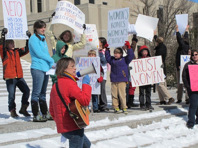 FILE - In this March 25, 2013 file photo, Kris Kitko leads chants of protest at an abortion-rights rally at the state Capitol in Bismarck, N.D. Rival legal teams, each well-financed and highly motivated, are girding for high-stakes court battles over the coming months on laws enacted in Arkansas and North Dakota that would impose the nation's toughest bans on abortion. The Arkansas law, approved March 6 when legislators overrode a veto by Democratic Gov. Mike Beebe, would ban most abortions from the 12th week of pregnancy onward. On March 26, North Dakota went even further, with Republican Gov. Jack Dalrymple signing a measure that would ban abortions as early as six weeks into a pregnancy, when a fetal heartbeat can first be detected. (AP Photo/James MacPherson, File)