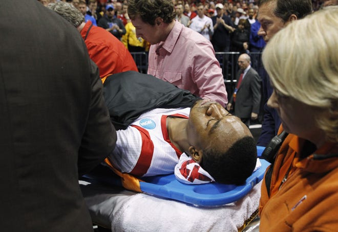 Louisville guard Kevin Ware is taken off of the court on a stretcher after his injury during the first half of the Midwest Regional final against Duke in the NCAA college basketball tournament Sunday in Indianapolis.