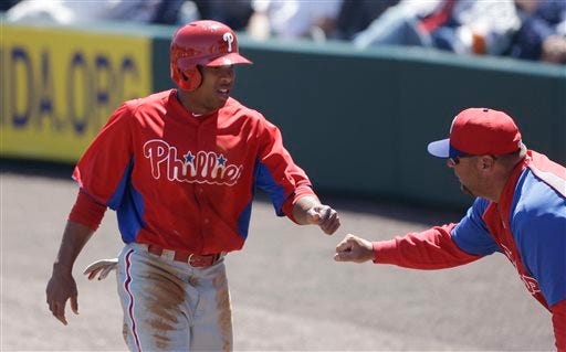 Philadelphia Phillies' Ben Revere, left, is congratulated as he approaches the dugout after scoring from third on teammate Michael Young's sacrifice fly during the first inning of an exhibition spring training baseball game against the Detroit Tigers, Wednesday, March 27, 2013 in Lakeland, Fla. (AP Photo/Carlos Osorio)