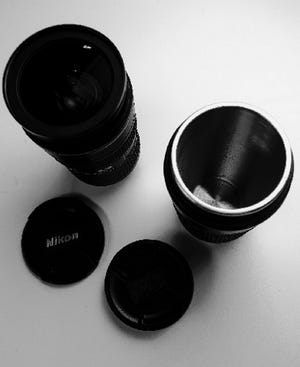 A Nikkor AF-S 24-70mm f/2.8 ED N wide angle zoom lens, left, and a mug designed to look like the lens.