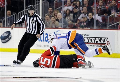 Linesman John Grandt, left, reacts as Islanders' Matt Martin, top, (17) and Devils Tom Kostopoulos (25) fight during the first period Monday, April 1, 2013, in Newark, N.J. The Islanders won 3-1.