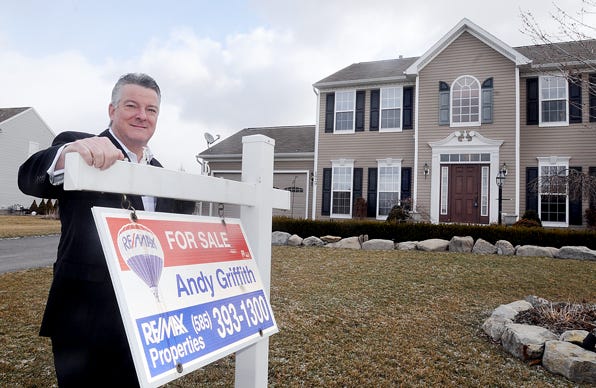 Andy Griffith, broker/owner of RE/MAX Properties in Canandaigua, stands with the sign for a house he is representing on Stablegate Drive in Canandaigua. Griffith said Ontario County is moving toward a more balanced housing market.