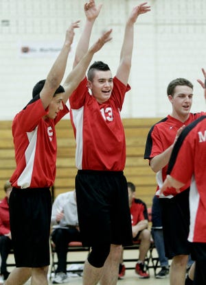 Milford's Kane Wittorff (middle) celebrates with his teammates after scoring a point during the Scarlet Hawks' 3-0 sweep of Marlborough on Tuesday.