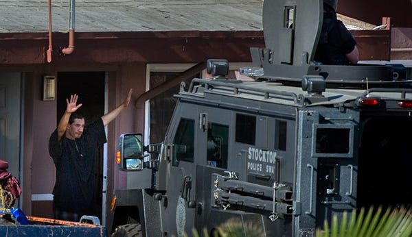 Alejandro Ruvalcaba comes out of room 105 with his hands raised during a standoff at the Capri Motel in Stockton.