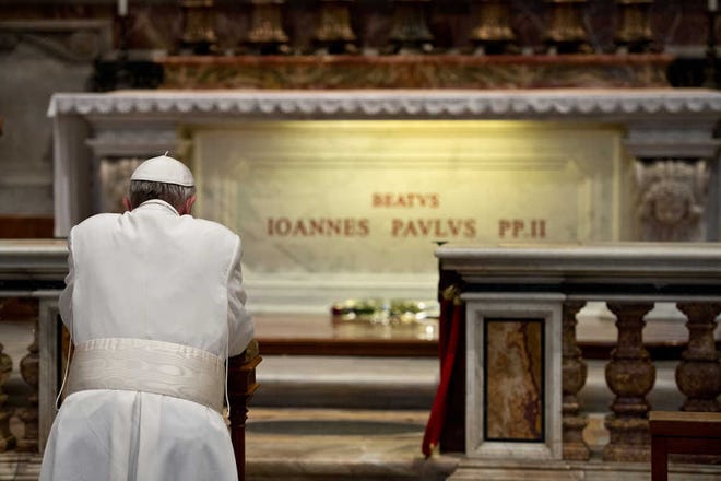 In this picture made available by the Vatican newspaper L'Osservatore Romano, Pope Francis prays in front of the tomb of Pope John Paul II, at the Vatican Tuesday, April 2, 2013. Pope Francis has prayed before the tomb of Pope John Paul II on the eighth anniversary of the much-beloved pontiff's death. In his three weeks as pope, Francis has jolted the Catholic Church with several gestures that broke with tradition, including renouncing certain liturgical vestments and washing the feet of a Muslim woman during a Holy Thursday ritual re-enacting Jesus Christ's washing of his apostles' feet. (AP Photo/L'Osservatore Romano)