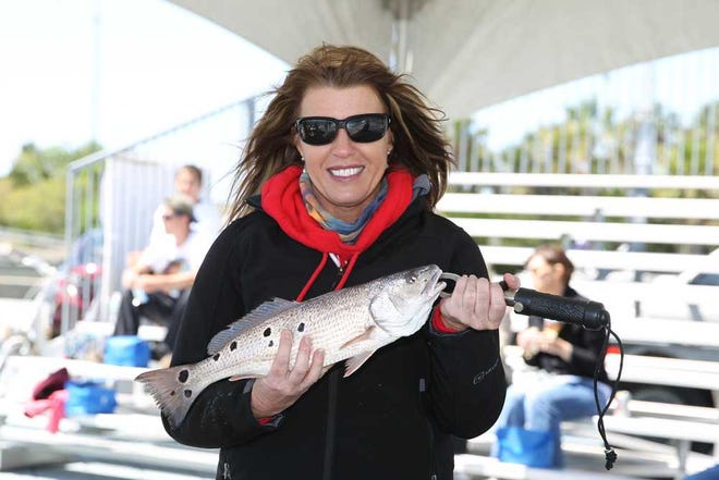 Gary McCullough for the Times-Union Anna-Marie Stokes of Orange Park holds up her winning 13-spot fish at the Times-Union Redfish Roundup charity tournament at Sisters Creek on Saturday.