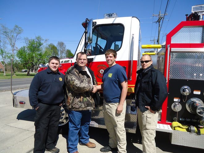 Firefighter Alex Soletske, Captain Justin Pauler and Captain Scott Cohenour welcome Robbie Villenurve to the rank of Firefighter in the St. Amant Community.