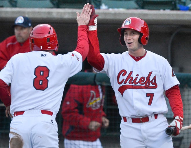 Charlie Tilson of the Chiefs (8) gets a hand from teammate Jordan Walton (7) after scoring during a Midwest League game at Peoria Chiefs Stadium on Friday.