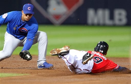 Atlanta Braves runner Andrelton Simmons, right, slides safely into second under the tag of Chicago Cubs shortstop Starlin Castro in the fourth inning of their baseball game, Friday, April 5, 2013, in Atlanta. (AP Photo/Butch Dill)