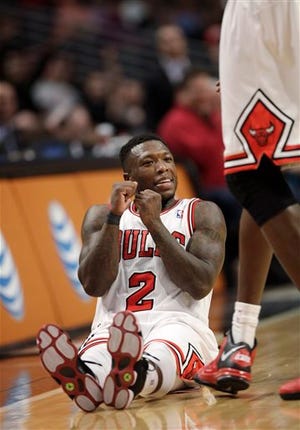 Chicago Bulls' Nate Robinson does a dance while sitting on the floor after making a 3-point basket late in the fourth quarter as the Bulls defeated the Orlando Magic 87-86 in an NBA basketball game Friday, April 5, 2013, in Chicago. (AP Photo/Charles Cherney)