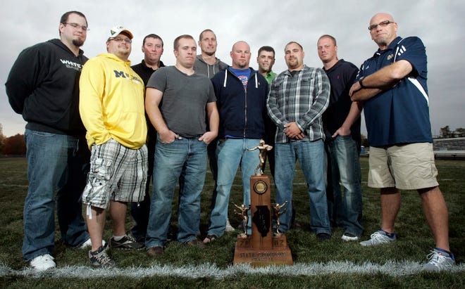 Players and coaches from the 2002 South Beloit state championship football team Brett Gerue (from left), Alan Klemett, Rich Rowlett, Justin Staver, Jacob Dunkel, Jason Goldsworthy, Dave Bennington, Brad Baker, Gary Eschen and Drew Potthoff stand with their trophy Wednesday, Oct. 3, 2012, on the football field at South Beloit High School.