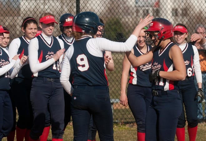 The CB East softball team clears the bench to celebrate a two run homer by Caroline Shoenewald (right) in the 5th inning of a game against North Penn in Lansdale on Friday afternoon. Schoenewald also homered in the sixth of the Patriots 11-3 victory over the Maidens.
