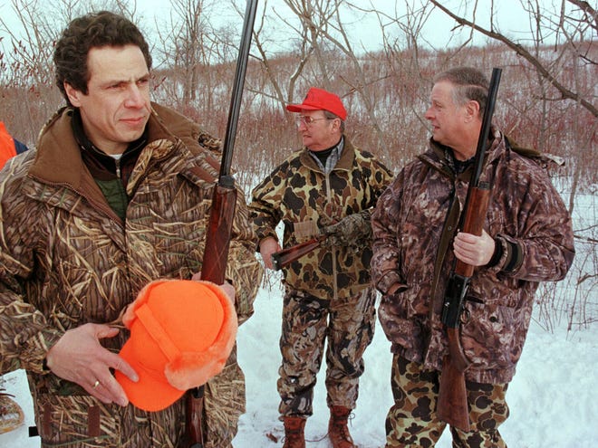 In this Sunday, Jan. 23, 2000 file photo, Housing and Urban Development Secretary Andrew Cuomo, left, gets ready for a pheasant hunt in Savannah, N.Y., as New York assemblymen Dick Smith, center, of Buffalo, N.Y., and Michael Bragman, right, of Cicero, N.Y., stand with him.