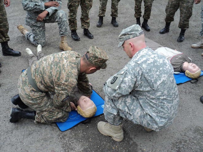 Kansas Army National Guard Staff Sgt. Brian Martin works with an Armenian soldier while others observe. The exercise, using dummies, was intended to access how much the Armenians knew about lifesaving techniques and help craft a curriculum, Martin said.