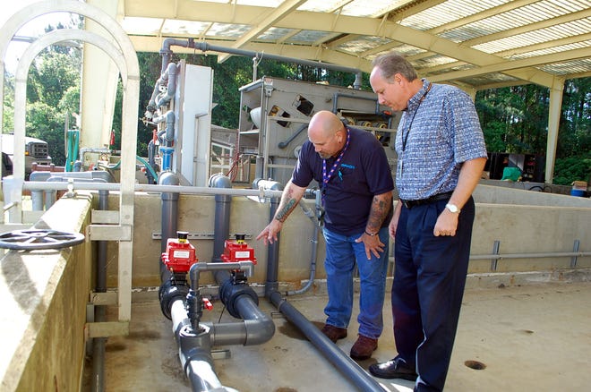 Casey Cochran, utilities supervisor for Richard Brady and Associates, left, points out some of the unique functions of the solenoid valve for the Clean B Solution to Jay Caddy, commodity manager for NAS Jax Public Works Utilities and Energy Management. The valves filter the water after it is disinfected either into the BCR Chemical Sludge Treatment System or back to the wasterwater treatment plant for retreatment.