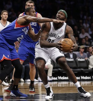 The Nets' Reggie Evans (30) prepares to go up for a shot as the Sixers' Thaddeus Young (left) defends during Tuesday night's game in Brooklyn.