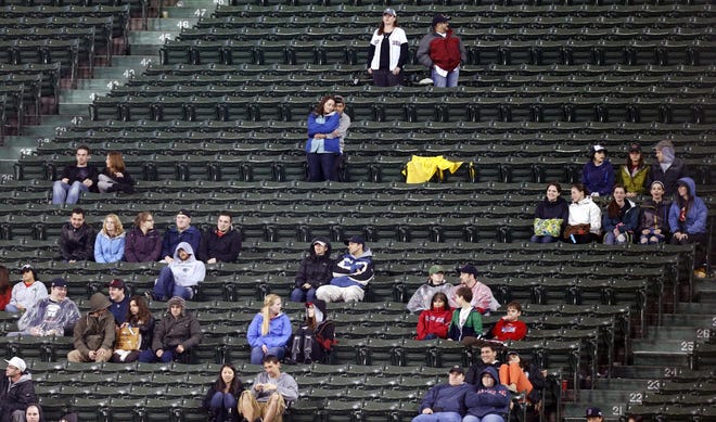 Scattered fans sit in the bleachers at Fenway Park in the eighth inning of the Red Sox's baseball game against the Baltimore Orioles in Boston, after the Red Sox officially announced that their nearly 10-year streak of home sellouts had ended on Wednesday.