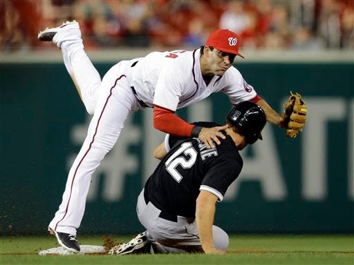 Washington Nationals second baseman Danny Espinosa, top, falls over Chicago White Sox's Conor Gillaspie (12) while turning a double play during the fifth inning of an interleague baseball game at Nationals Park, Wednesday, April 10, 2013, in Washington.