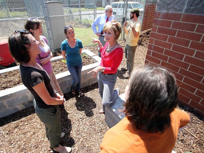 Detention center assistant director Cathy Wood, right facing, and Druid City Garden Project director Lindsay Turner, second from left, talk about the new garden at the Tuscaloosa County Juvenile Detention Center on Wednesday.