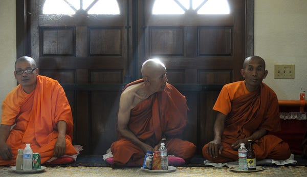 Monks sit before afternoon prayer Friday at the Wat Dhammararam Buddhist Temple, which is hosting a five-day Cambodian New Year celebration.