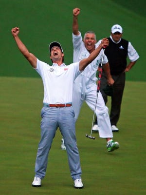 Adam Scott and his caddie, Steve Williams, celebrate as Angel Cabrera looks on Sunday as Scott wins the Masters.