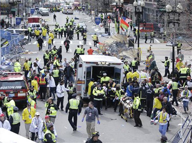 Medical workers aid injured people at the finish line of the 2013 Boston Marathon following an explosion in Boston, Monday, April 15, 2013.