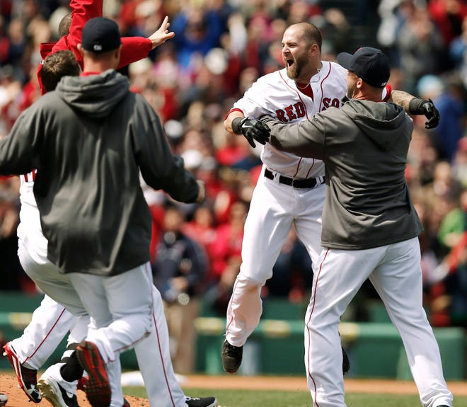 Red Sox designated hitter Mike Napoli (second from right) is mobbed by teammates after his game-winning double scored Dustin Pedroia during the ninth inning of Boston's 3-2 win over the Tampa Bay Rays on Monday.