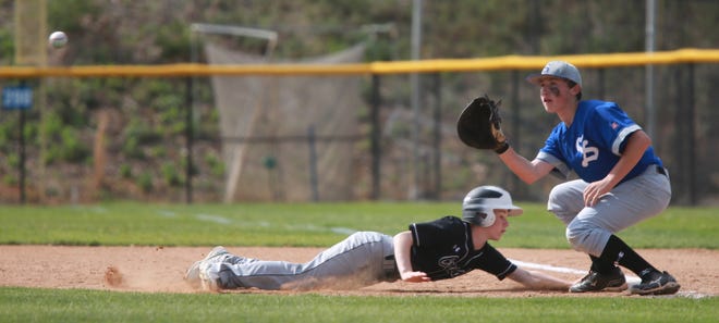 Crest Middle's Nick Melton dives back to first to avoid being tagged out by Shelby Middle's Will Stites during Tuesday night's game at Shelby Middle.