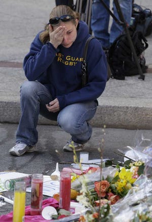 Julio Cortez Associated Press illian Blenis, 30, of Boston, reacts while stopping at a makeshift memorial. The city continues to cope following Monday's explosions near the finish line of the Boston Marathon.