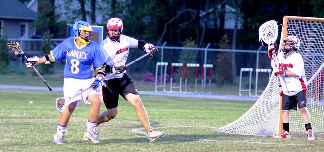 Jacksonville's Avery Waters defends against Laney's Ben West while goalie Alex Leifheit keeps a close eye on the proceedings as well Wednesday night. Laney beat the Cardinals 17-1.